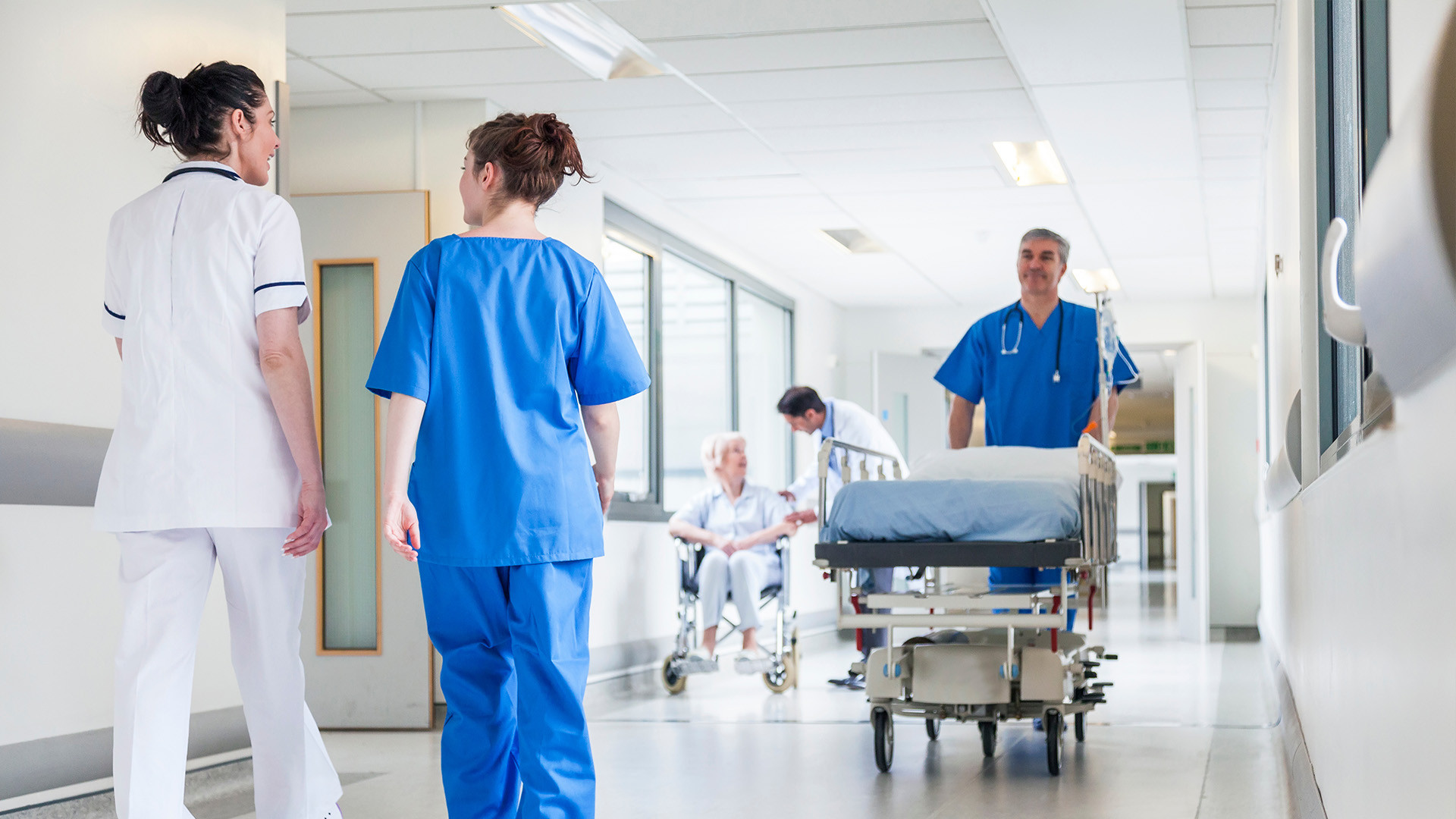 Présentation d'un hôpital avec plusieurs infirmières et brancardier qui traversent les couloirs